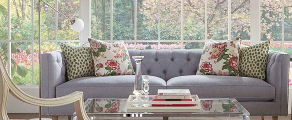  Tufted sofa with refreshing spring floral and soft green pillows.